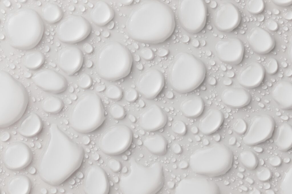 Close-up of abstract white water droplets on a smooth surface, ideal for background or texture.