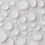 Close-up of abstract white water droplets on a smooth surface, ideal for background or texture.